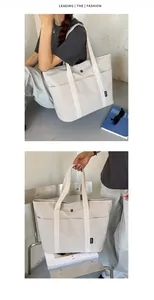 Minimalistische cremefarbene Segeltuchtasche mit Vordertasche und Kontrastgriffen