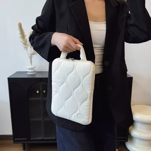 Housse de portable matelassée blanche portée par une femme dans un blazer noir élégant.