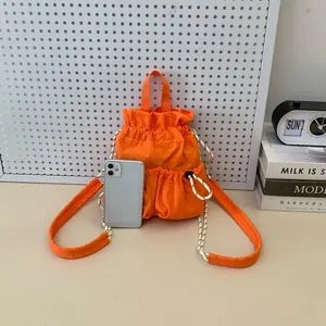 Detailansicht eines orangefarbenen wasserdichten Nylon-Rucksacks mit Handy zum Größenvergleich