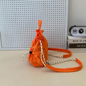 Detailansicht eines leuchtend orangen, wasserdichten Nylon-Rucksacks mit Kordelzug