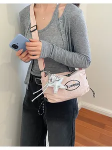 Stylish lightweight pink crossbody bag worn by a model in a clean lifestyle interior