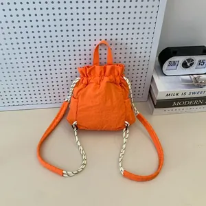 Detailansicht des orangefarbenen Nylon-Rucksacks mit robusten geflochtenen Seilgurten.