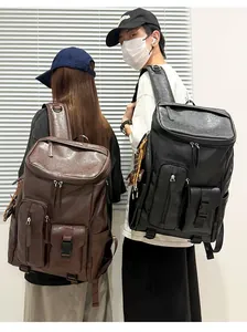 Two people wearing retro large capacity business backpacks in brown and black