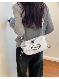 Back view of model showcasing the white crossbody bag with a metallic star charm accessory