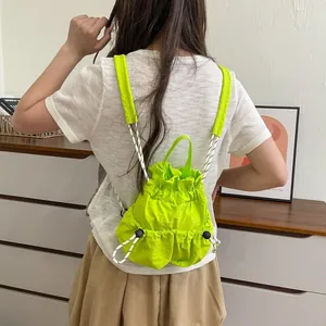 Detailansicht eines leuchtend lindgrünen Nylon-Rucksacks mit Kordelzug am Modell.