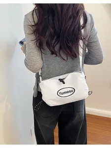 Detailed back view of a person wearing a white lightweight minimalist fashion crossbody bag