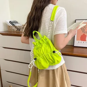 Detailansicht des neongrünen wasserdichten Nylon-Rucksacks mit Kordelzug an einem Modell