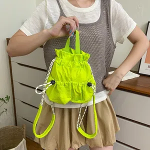 Modell mit neongrünem Nylon-Rucksack mit Kordelzug und verstellbaren Streifengurten
