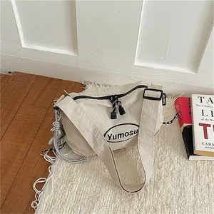 Minimalist beige crinkled nylon crossbody bag with stylish rope strap and logo detail