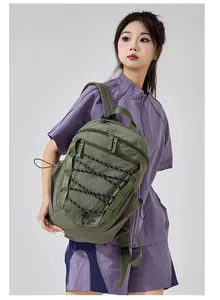 Asian female model wearing a large olive green hiking backpack with bungee cord design