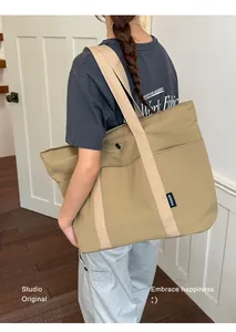 Große khakifarbene Tragetasche an der Schulter, ideal für Arbeit oder Studenten
