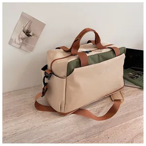 Vue détaillée du sac de sport beige et vert GUOMISS sur une surface de table en marbre