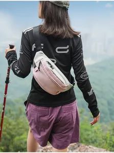 Details von rosa und grauem wasserdichten Brustbeutel, getragen von Wanderer auf einem Bergpfad.