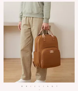 Elegante bolsa de pañales multifuncional marrón en un entorno de estilo de vida.