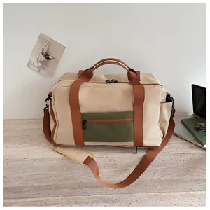 Vue détaillée d'un sac de voyage en toile beige avec poche verte zippée pour sport et fitness