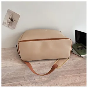 Vue détaillée du fond d'un sac de sport et de voyage beige montrant la texture du tissu