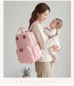 Mochila pañalera rosa de gran capacidad mostrada por una madre con su bebé en un entorno natural