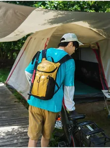 Mochila de senderismo amarilla impermeable llevada por una persona en un camping al aire libre