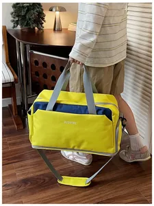 Grand sac de sport jaune et bleu marine porté par une personne dans un cadre lifestyle
