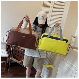 Grands sacs de sport marron et jaune présentés par un mannequin asiatique en salle