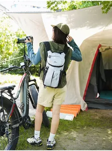 Mochila deportiva blanca con patrón de rejilla usada en un escenario de camping