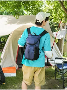 Hombre que lleva una mochila de senderismo azul resistente al agua en un camping