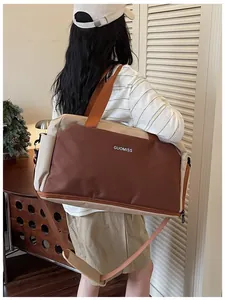 Vue arrière d'une personne portant un grand sac de sport marron et beige pour le voyage