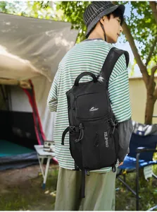 Hombre que lleva una mochila negra impermeable para exteriores en un entorno de camping