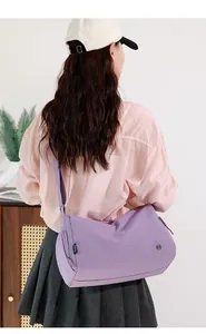 Detail view of purple waterproof sports gym bag worn by model in casual setting