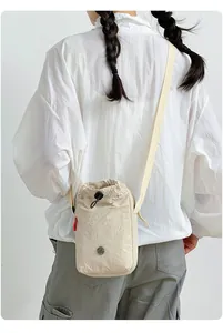 Bolso bandolera beige de nailon con cordón para mujer en un estilo de vida casual