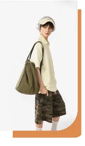 Detail shot of large olive green nylon tote bag on male model for gym or daily commute.