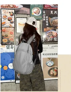 Lightweight gray commute backpack styled in a trendy urban lifestyle street setting.
