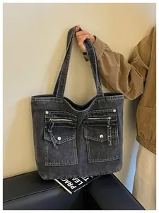 Detailed view of large capacity washed denim tote bag with functional utility front pockets