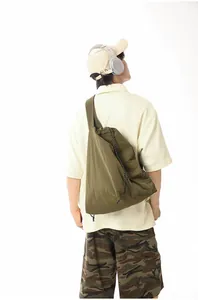 Back view of a minimalist large olive green nylon sling bag worn by a male model