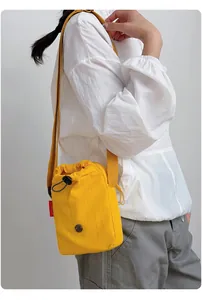Bolso bandolera amarillo de nailon para móvil con cierre de cordón y etiqueta