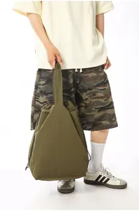 Close-up of large olive green nylon tote bag held by model for sports and fitness use