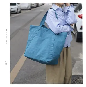 Nahaufnahme einer blauen Nylon-Einkaufstasche, getragen von einem Modell