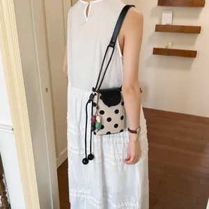 Chic polka dot bucket shoulder bag for women, stylish crossbody phone bag with cute bead charms.