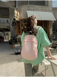 Lightweight pink minimalist backpack shown in a stylish outdoor lifestyle setting