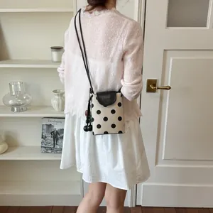 Chic polka dot mini crossbody bag, cute bucket phone bag with stylish leather flap.
