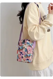 Primer plano de bolso bandolera para mujer con flores y mariposas en modelo