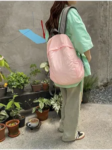 Back view of a lightweight pink minimalist backpack worn by a person outdoors now