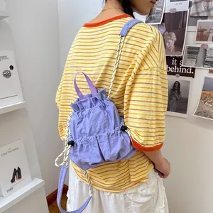 Rückansicht eines weiblichen Models mit lila wasserdichtem Nylon-Rucksack mit Kordelzug