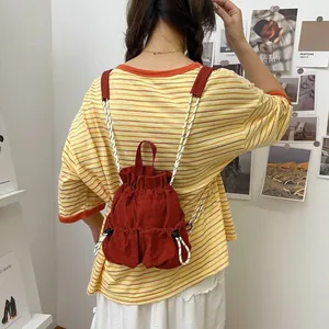 Funktionaler roter wasserdichter Nylon-Rucksack mit Kordelzug in der Rückansicht am Modell