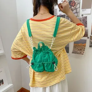 Detailansicht eines grünen Nylon-Rucksacks mit Kordelzug, von hinten getragen