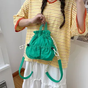 Nahaufnahme eines grünen Nylon-Rucksacks mit Kordelzug für lässige Outdoor-Reisen
