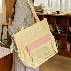 Detalle de bolso tote de nylon crema con bolsillo de estrella transparente y solapa rosa