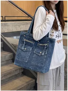 Large blue acid wash denim tote bag shown worn by a model on a shoulder for commuting