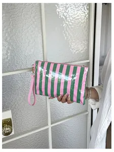 Close-up of pink and green striped cosmetic pouch with glossy finish and wristlet