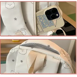 Vista detallada de mochila blanca para estudiantes con bolsillo lateral y asa de transporte